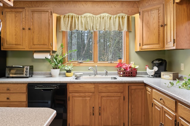 kitchen featuring dishwasher, light countertops, a sink, and a toaster