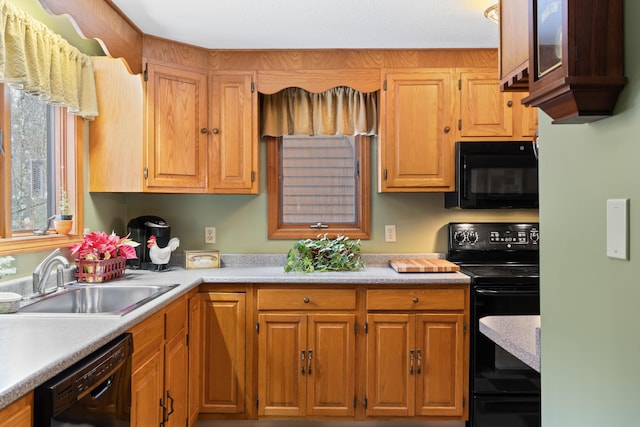 kitchen with black appliances, a sink, and light countertops