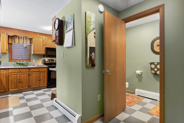 kitchen featuring a baseboard radiator, light countertops, black appliances, baseboard heating, and light floors