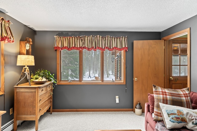 sitting room with carpet floors, a baseboard radiator, baseboards, and a textured ceiling