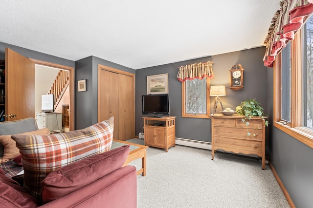 living area with baseboards, stairs, a baseboard heating unit, and light colored carpet