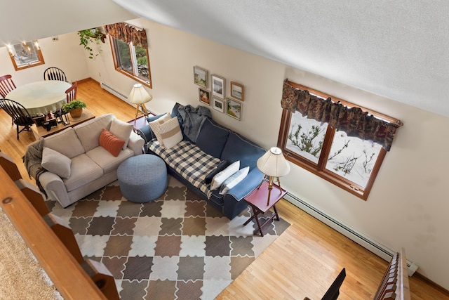 living room with a baseboard radiator, a textured ceiling, and wood finished floors