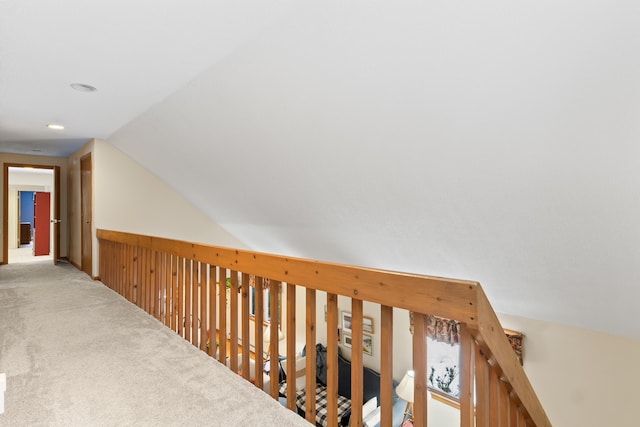 hallway featuring lofted ceiling and carpet flooring