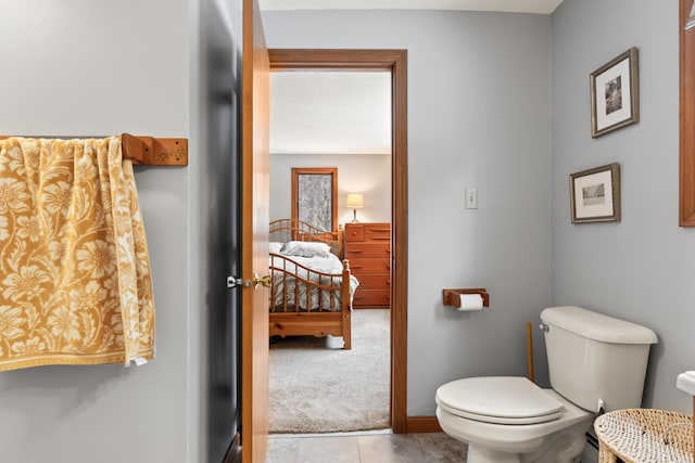 bathroom featuring toilet, baseboards, and tile patterned floors