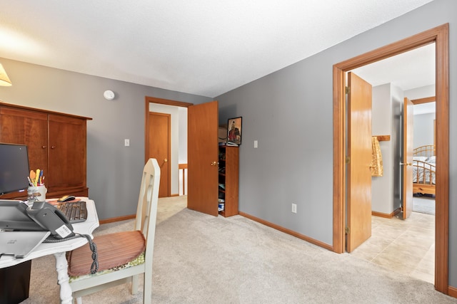 office space with baseboards and light colored carpet