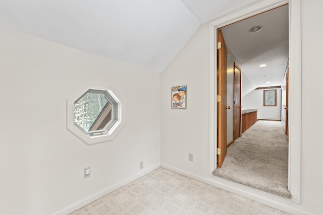 interior space featuring vaulted ceiling, carpet floors, and baseboards