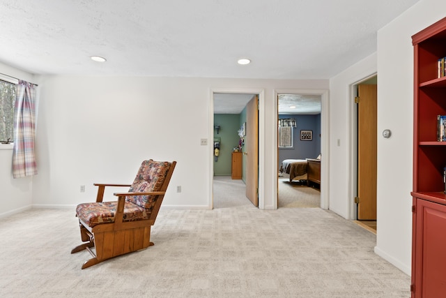 living area with recessed lighting, baseboards, a textured ceiling, and light colored carpet