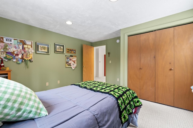 bedroom with a textured ceiling, a closet, and carpet flooring