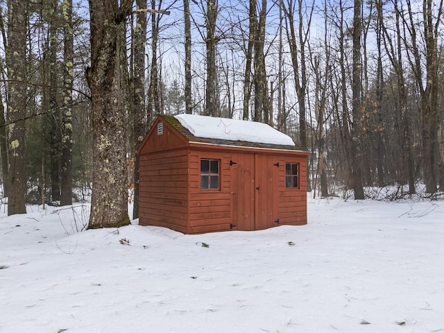 snow covered structure featuring an outdoor structure