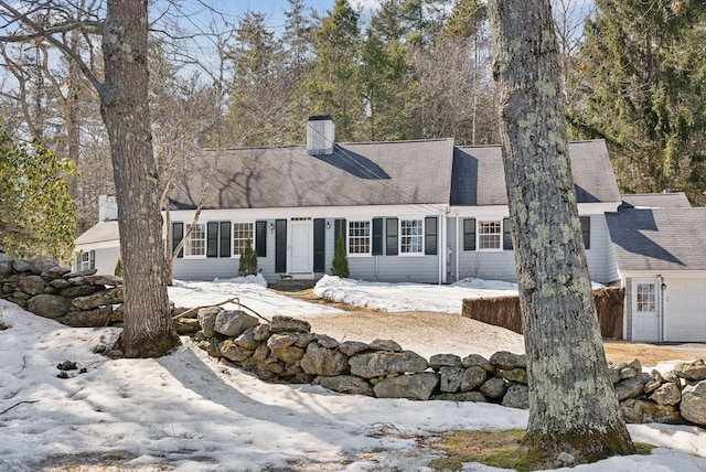 view of front facade featuring a chimney and roof with shingles