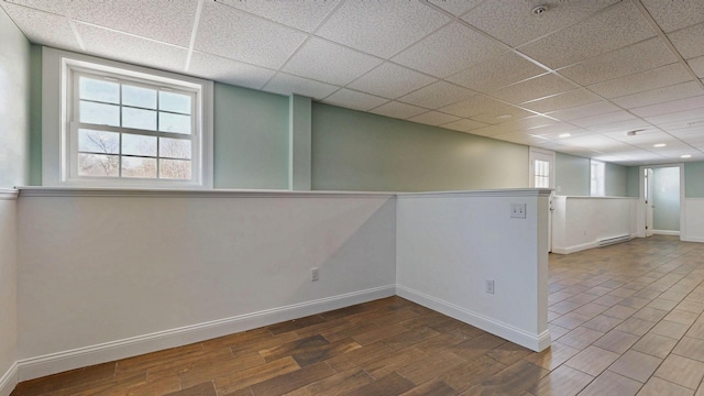 7 Dogleg Dr, Windham, ME 04062 - below grade area with wood finished floors, baseboards, a paneled ceiling, and a baseboard heating unit