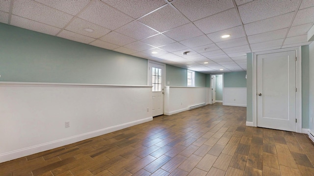 7 Dogleg Dr, Windham, ME 04062 - below grade area with a baseboard radiator, wood finished floors, recessed lighting, baseboards, and a paneled ceiling