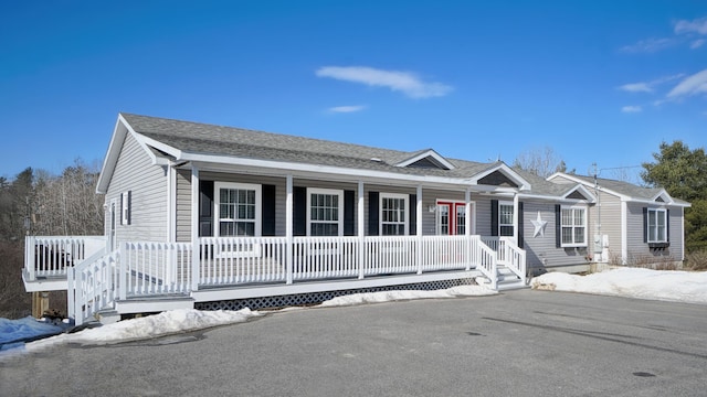 single story home featuring a porch and a shingled roof