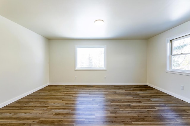 spare room featuring baseboards and wood finished floors