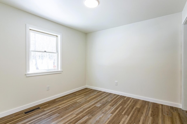 unfurnished room with visible vents, baseboards, and wood finished floors