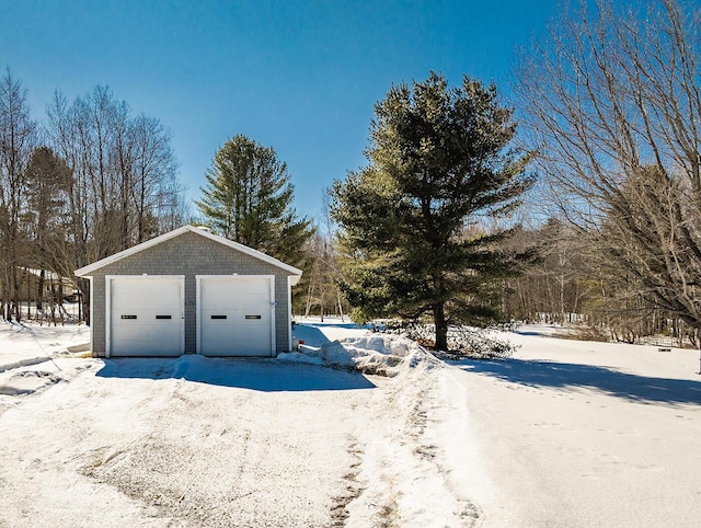 snow covered garage with a garage