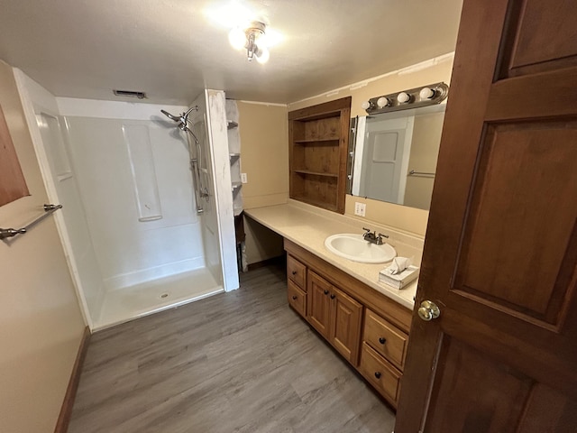 35 Bath Rd, Brunswick, ME 04011 - bathroom featuring walk in shower, wood finished floors, vanity, and baseboards