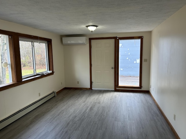 35 Bath Rd, Brunswick, ME 04011 - unfurnished room with a wall mounted AC, baseboards, a textured ceiling, wood finished floors, and a baseboard radiator