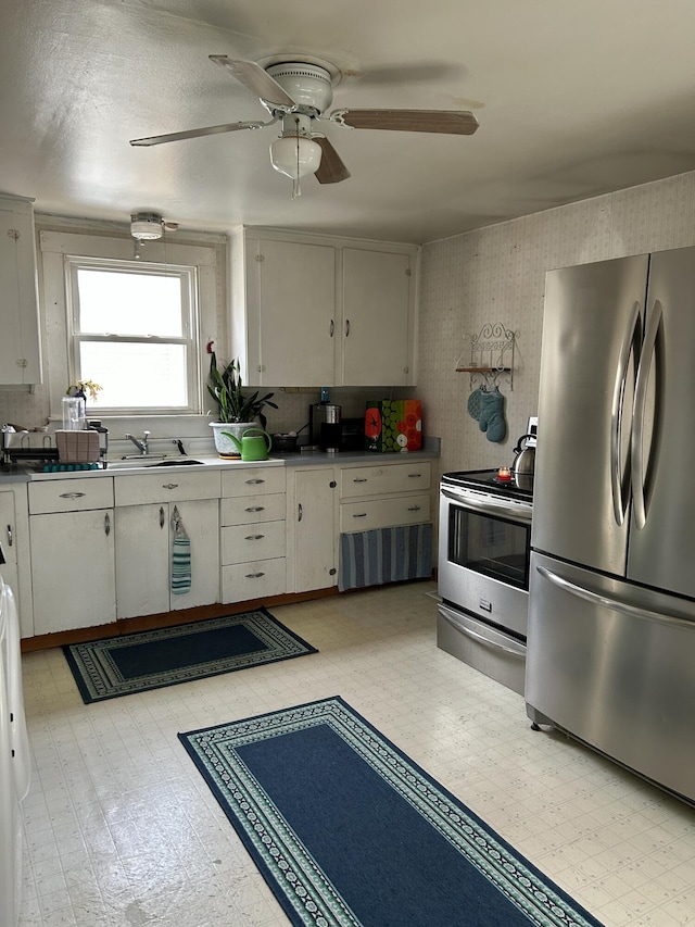 kitchen with light floors, stainless steel appliances, ceiling fan, and a sink