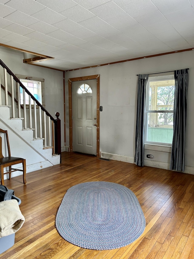 entryway featuring plenty of natural light, stairway, and hardwood / wood-style flooring