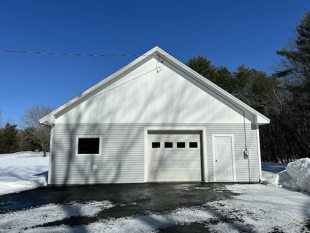 snow covered garage featuring a garage