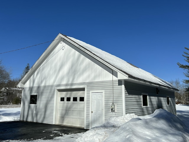 snow covered garage featuring a detached garage