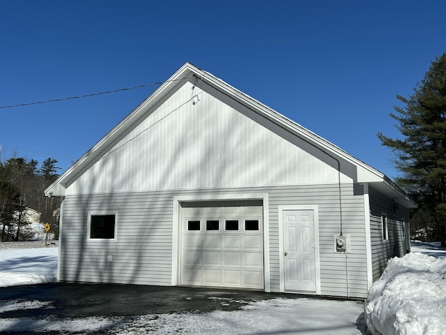 snow covered garage with a garage