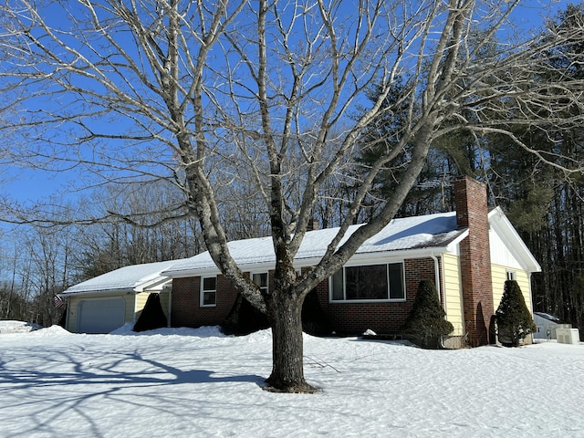 single story home with a garage, brick siding, and a chimney