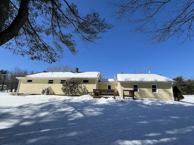 snow covered property featuring a chimney and a deck