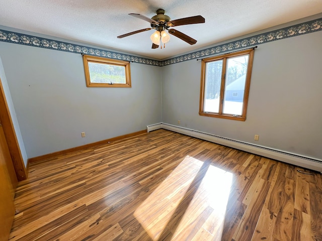 unfurnished room featuring ceiling fan, a textured ceiling, baseboards, and wood finished floors