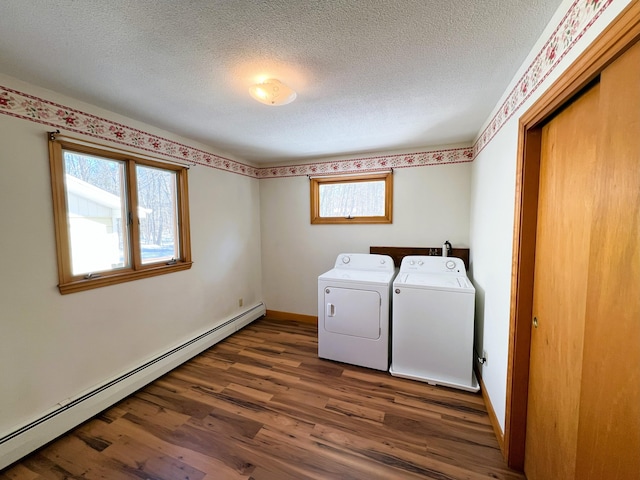 clothes washing area featuring dark wood-style floors, a baseboard radiator, a textured ceiling, washer and dryer, and laundry area