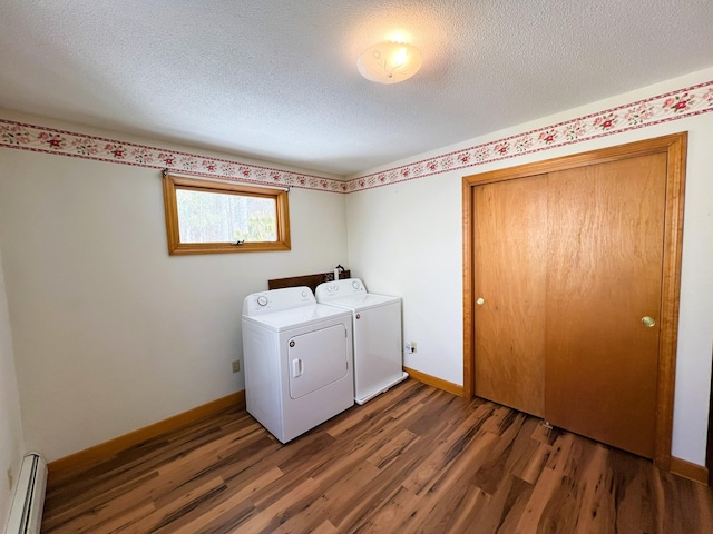 laundry room featuring laundry area, a baseboard heating unit, washer and clothes dryer, and wood finished floors