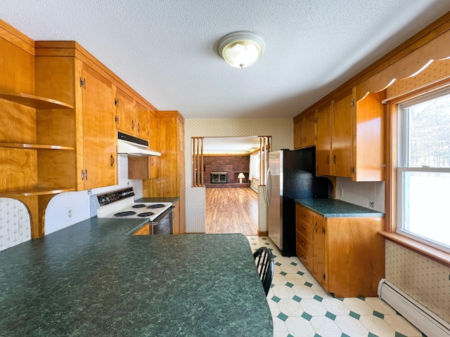 kitchen with under cabinet range hood, electric range, baseboard heating, and wallpapered walls