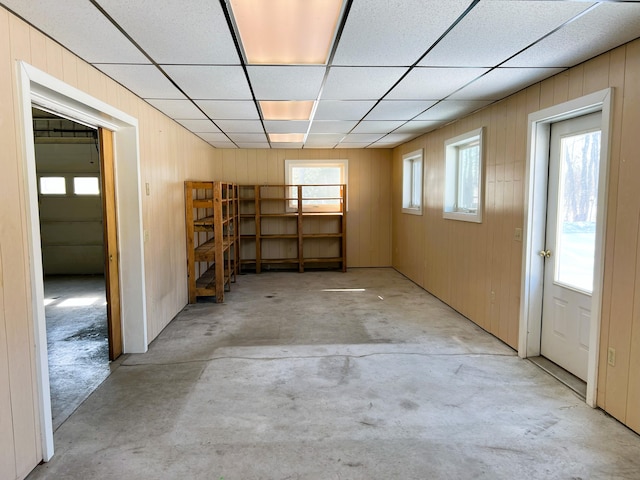 below grade area featuring a drop ceiling and wood walls