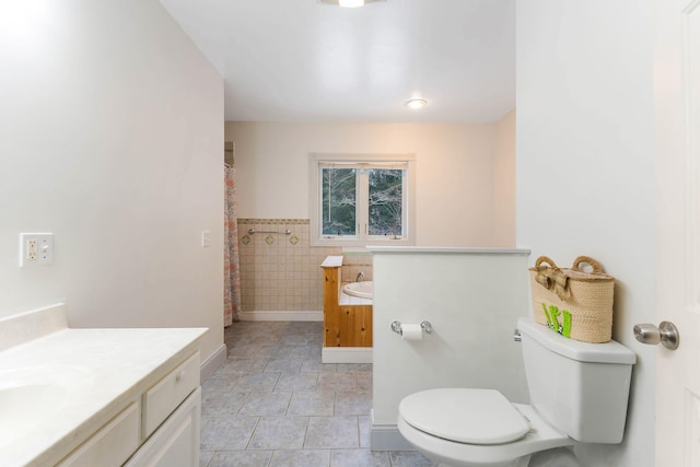 bathroom with a shower with shower curtain, vanity, toilet, and tile patterned floors