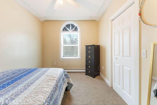 carpeted bedroom featuring a baseboard heating unit, a ceiling fan, and baseboards