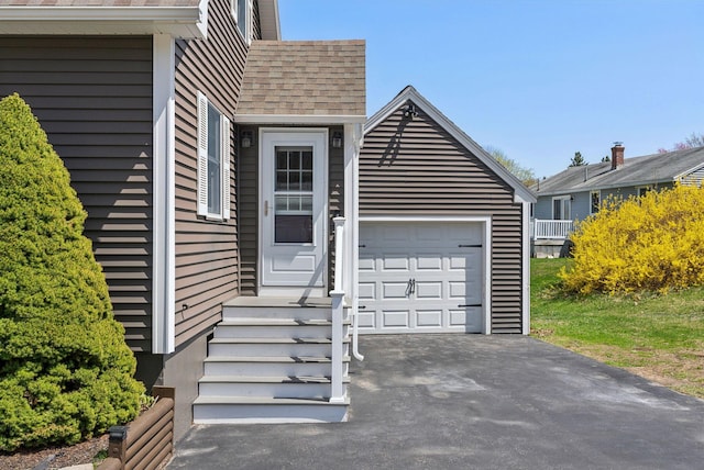 exterior space featuring a garage, aphalt driveway, and roof with shingles