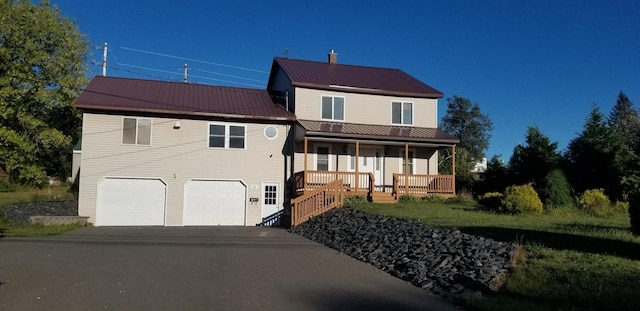 19 River Rd, Caribou, ME 04736 - view of front of home with metal roof, driveway, a porch, and an attached garage