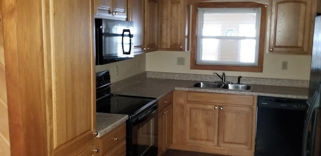 kitchen featuring black appliances, a sink, and light countertops