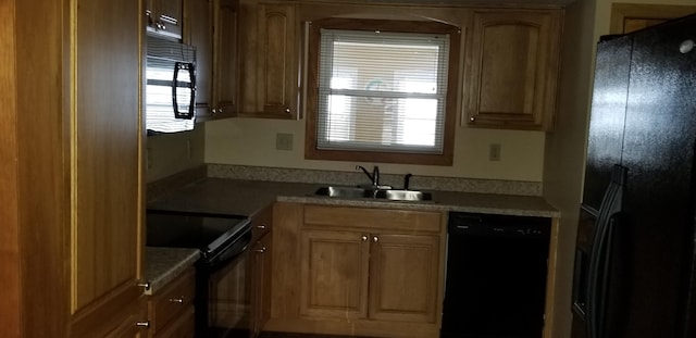 kitchen with plenty of natural light, light countertops, a sink, and black appliances