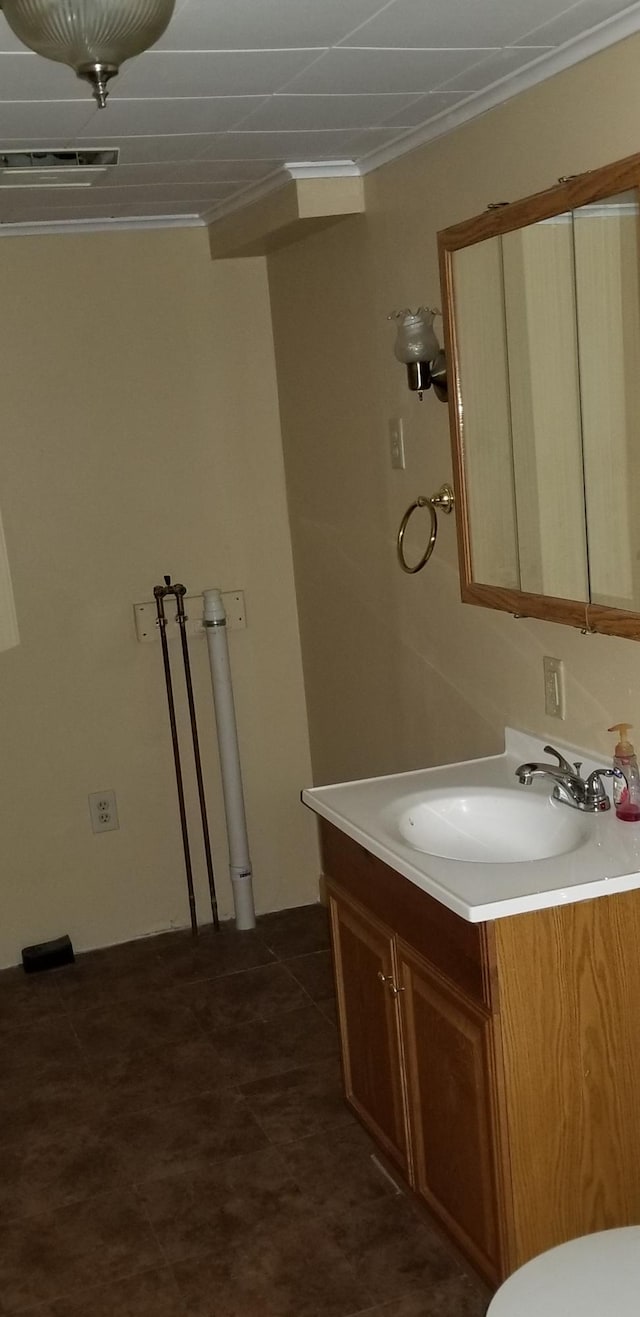 bathroom featuring visible vents, ornamental molding, and vanity