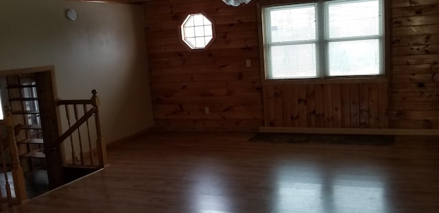 empty room with wood walls and wood finished floors