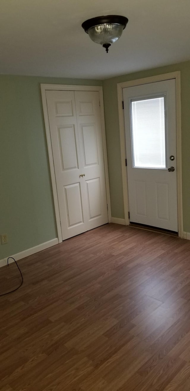 interior space featuring baseboards and wood finished floors