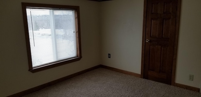 unfurnished room with baseboards