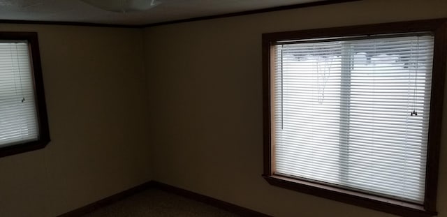 unfurnished room with crown molding and baseboards