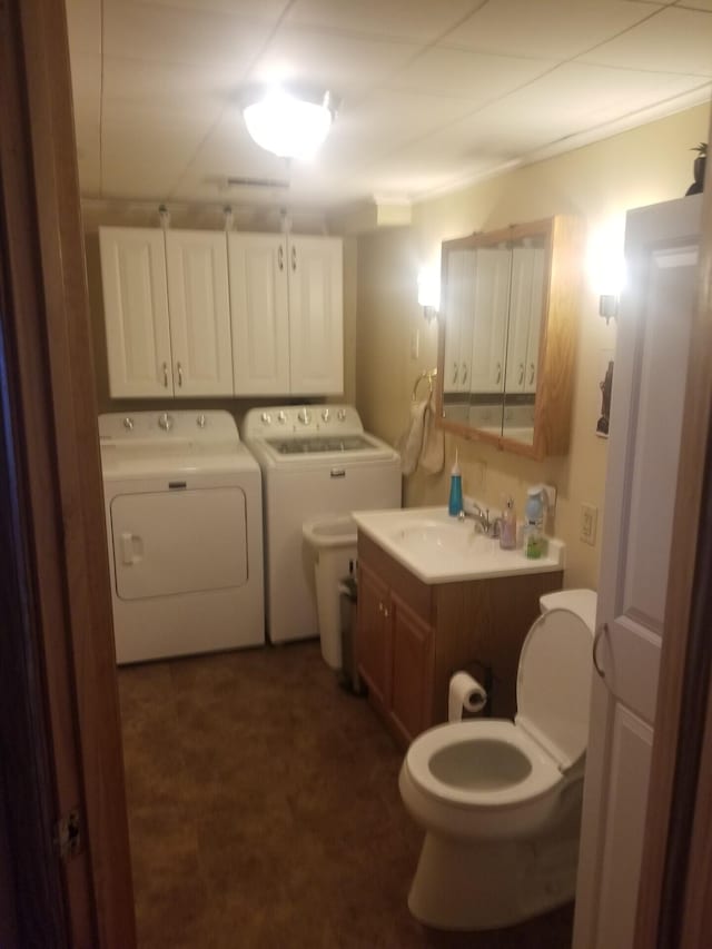 half bath with vanity, washing machine and dryer, and toilet