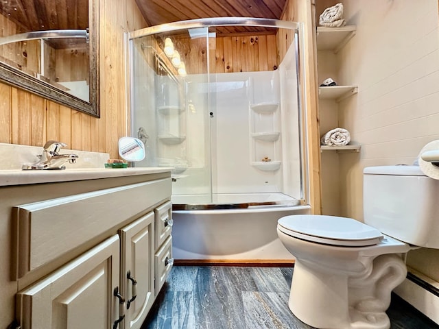 bathroom featuring toilet, combined bath / shower with glass door, wooden walls, vanity, and wood finished floors