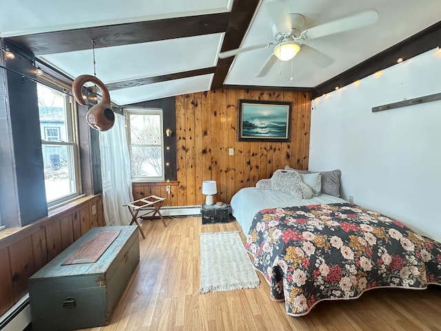 bedroom featuring a baseboard heating unit, lofted ceiling with beams, wooden walls, and wood finished floors