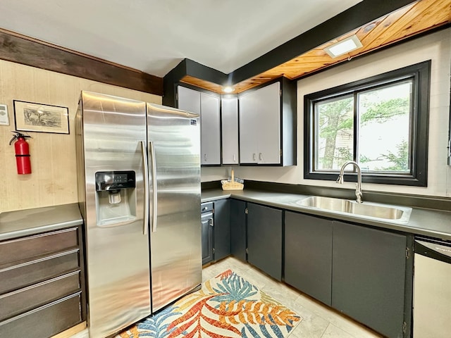 kitchen with gray cabinets, white dishwasher, a sink, and stainless steel fridge with ice dispenser