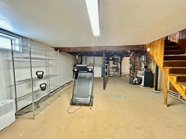 below grade area featuring stairway, a heating unit, and washer / clothes dryer